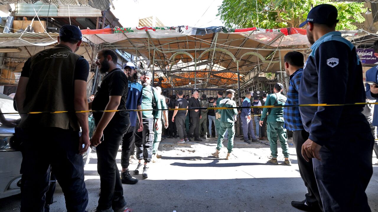 Syrian security forces and people gather at the site of an explosion at a cafe in the capital, Damascus, on July 2, 2026. 
