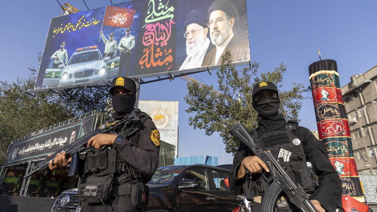 Iranian NOPO special police officers stand guard in front of a large portrait of Iran's late Supreme Leader, Ayatollah Ali Khamenei, at Valiasr square on July 3, 2026, in Tehran, Iran. 