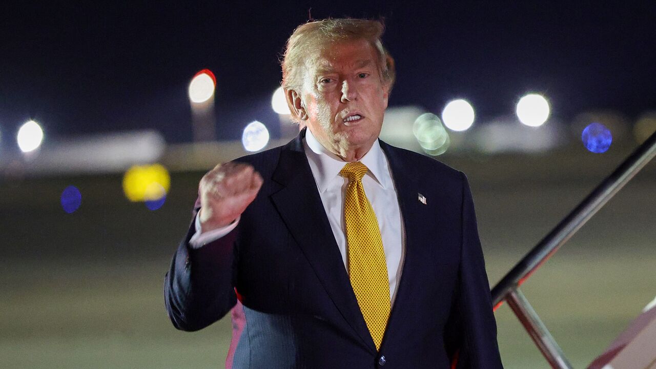 US President Donald Trump gestures as he steps off Air Force One to board the new Qatari-gifted Boeing plane, en route to the United States following his participation in the NATO Summit at Royal Air Force Mildenhall on July 8, 2026, in Mildenhall, England. 
