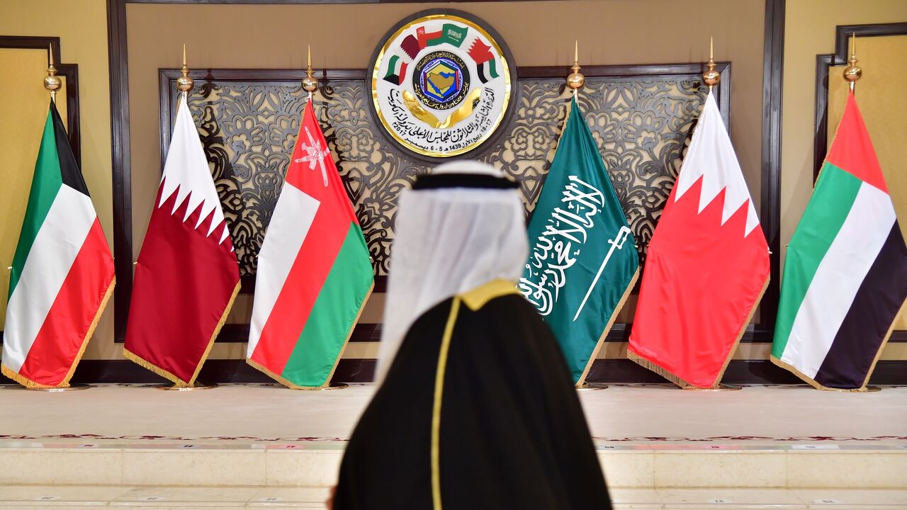 A man walks past the flags of the countries attending the Gulf Cooperation Council summit at Bayan palace in Kuwait City on Dec. 5, 2017.