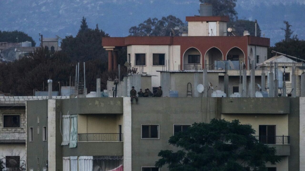 Israeli soldiers stand on the roof of a residential building in the Lebanese village of Zawtar al-Charkiyah