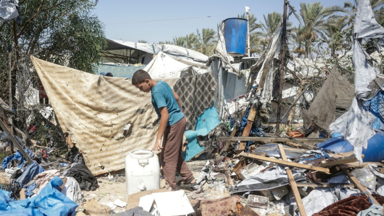 A displaced Palestinian youth inspects the damage of an alleged Israeli strike on a tent in Khan Yunis, in the southern Gaza Strip