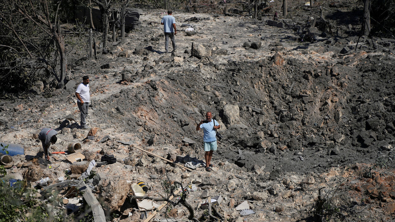 People and journalists stand at a site hit by Israeli strikes that occurred in the early hours of Thursday, according to Lebanon’s state news agency NNA, in Burj al-Shamali, southern Lebanon, August 6, 2026. REUTERS/Stringer     TPX IMAGES OF THE DAY