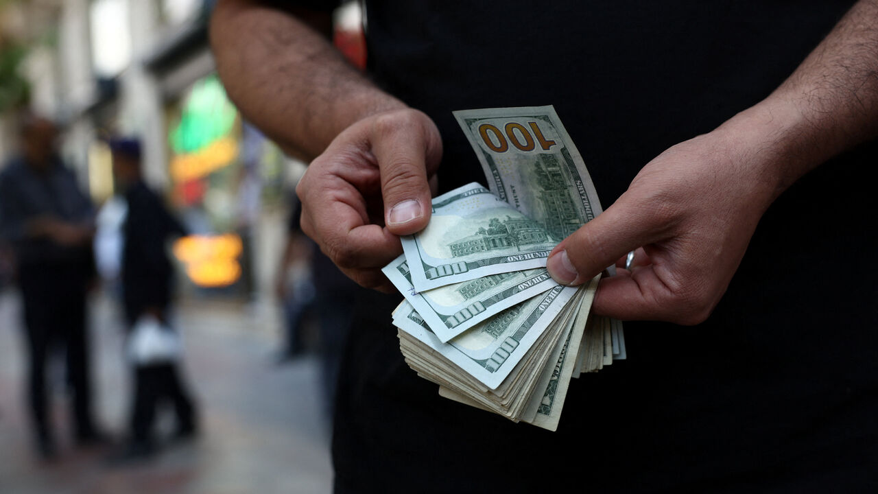 A currency dealer holds one-hundred-dollar bills in Tehran, Iran, May 2, 2026. Majid Asgaripour/WANA (West Asia News Agency) via REUTERS