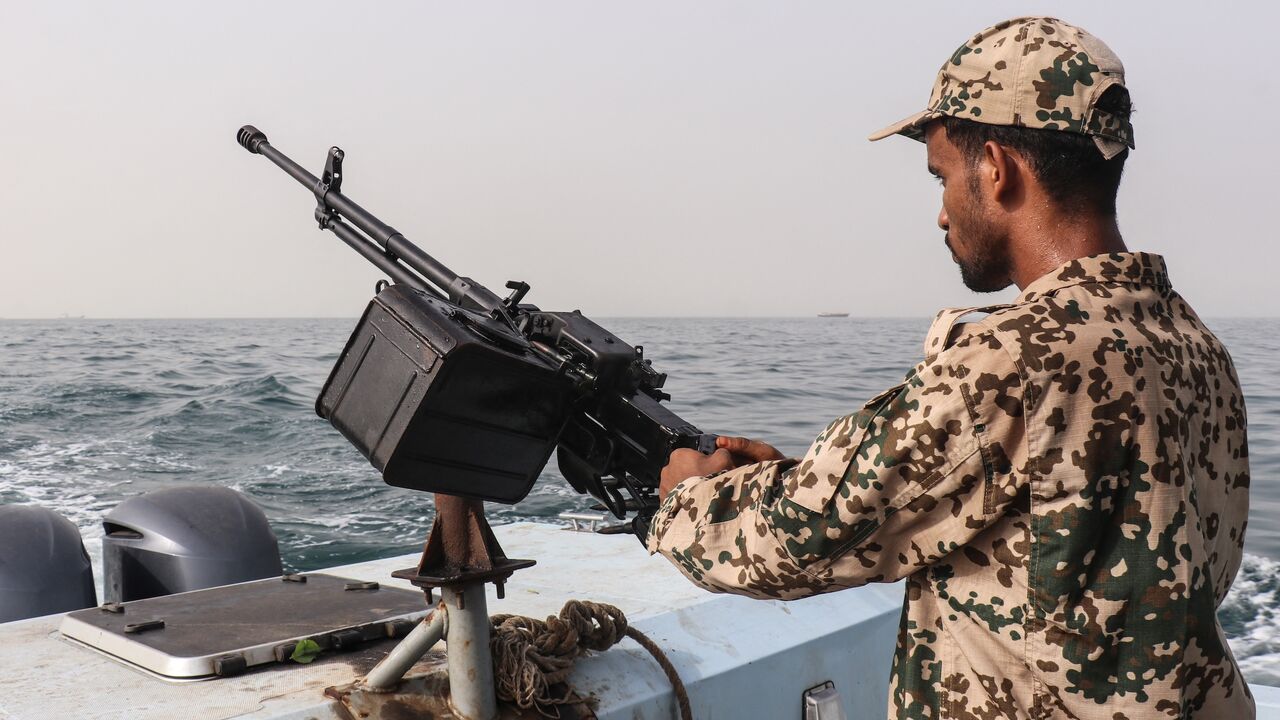 A sailor from the navy of Yemen's Aden-based internationally recognized government stands at a machine-gun position aboard a vessel patrolling a shipping lane off Hanish Island in the Red Sea on July 27, 2026.