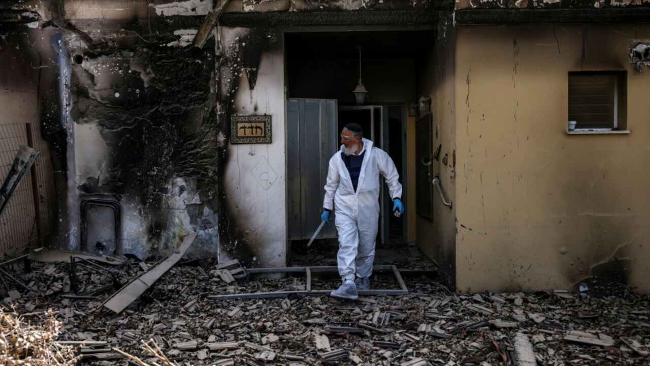 A volunteer of the Zaka Israeli ultra-Orthodox Jewish emergency response team searches through the debris in Kibbutz Beeri near the border with Gaza on October 20, 2023, in the aftermath of an attack by Palestinian militants on October 7