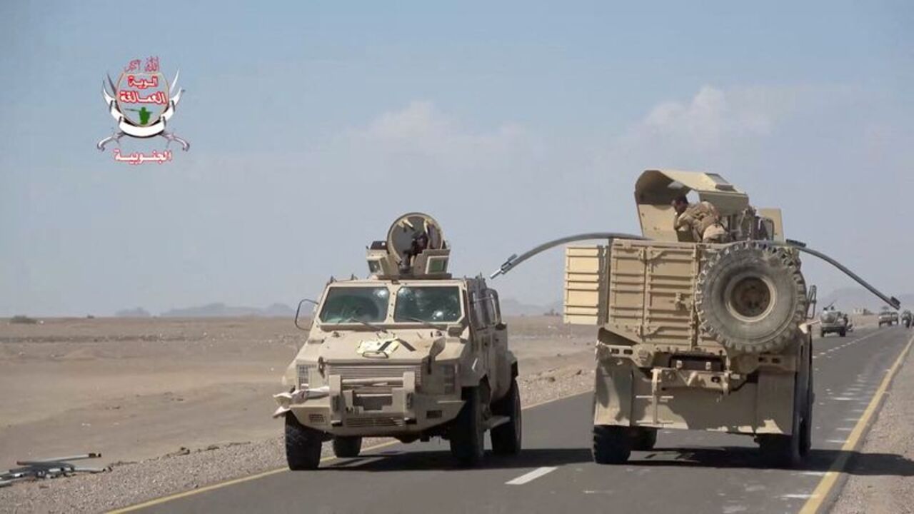 Military vehicles travel along a road during what Saudi-backed Yemeni government forces say was an advance against the Iran-backed Houthis, near Dhubab