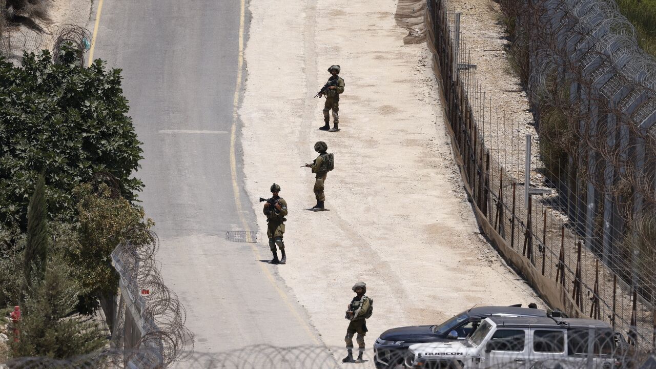 Israeli troops stand guard on the dividing line between the Israeli-annexed Golan Heights and Syrian, near Majdal Shams, July 16, 2025.