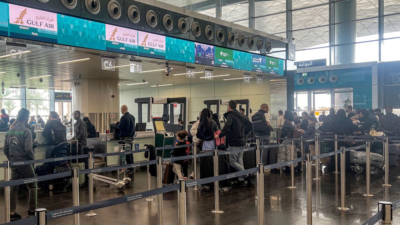 Travelers queue to check in their luggage at the terminal at King Khalid International Airport in Riyadh, on March 10, 2026. 