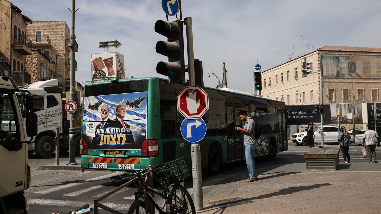 A bus bearing a campaign poster featuring Israeli Prime Minister and Likud party chairman Benjamin Netanyahu alongside US President Donald Trump drives through Jerusalem on October 26, 2026, on the eve of Israel's legislative elections. (Photo by AHMAD GHARABLI / AFP via Getty Images)