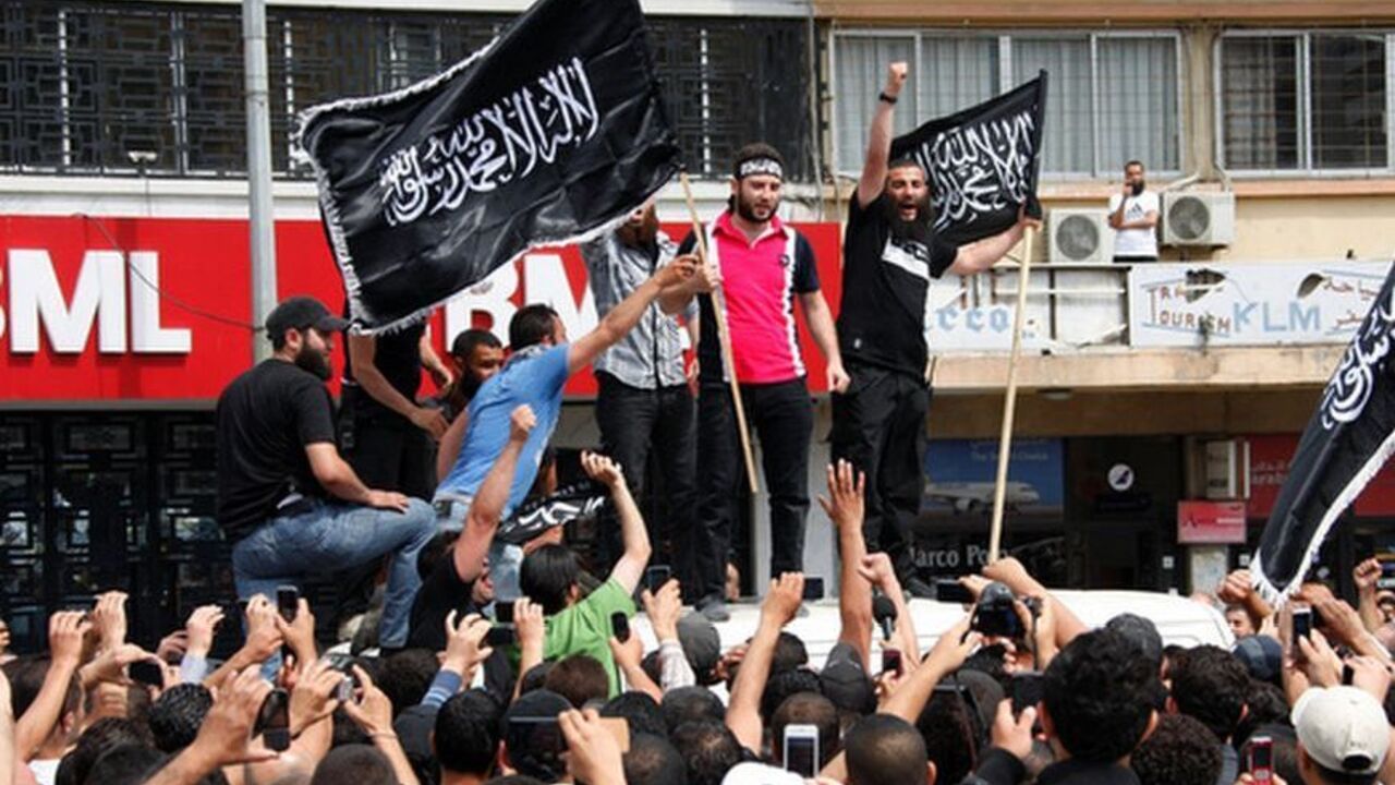 Sunni Islamist and anti-Syrian regime activist Shadi al-Moulawi stands on top of van as he is welcomed by crowd in Tripoli, northern Lebanon Sunni Islamist and anti-Syrian regime activist Shadi al-Moulawi (2nd R) stands on a top of a van as he carries a flag and is welcomed by a crowd shouting slogans, gesturing and filming him in Tripoli, northern Lebanon May 22, 2012. A court on Tuesday released on bail al-Moulawi, whose arrest earlier this month set off violent clashes in northern Lebanon that killed at least eight people. The flag reads: "There is no god but Allah, Muhammad is Allah's messenger". REUTERS/Omar Ibrahim (LEBANON - Tags: POLIT