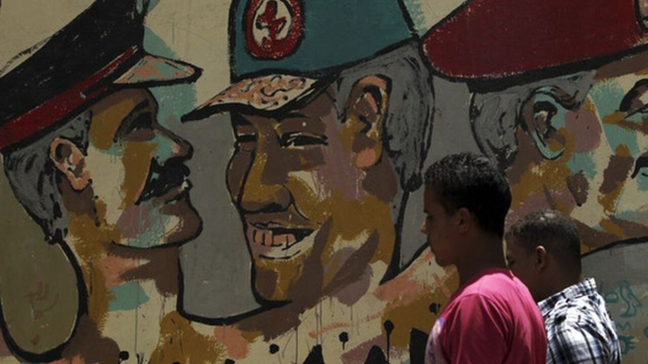 People walk in front of a wall sprayed with stencilled paintings depicting the Egyptian military council members in Cairo People walk in front of a wall sprayed with stencilled paintings depicting the Egyptian military council members, including Field Marshal Hussein Tantawi (C), the head of the ruling Supreme Council of the Armed Forces (SCAF), in Tahrir Square in Cairo May 24, 2012. Egypt resumes its first free presidential election on Thursday after voting passed off mostly calmly on the first day apart from a stone-throwing attack on candidate Ahmed Shafiq, who was premier for a few days before Hosni Mubarak fell. REUTERS/