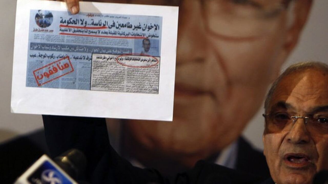Former Prime Minister and current presidential candidate Ahmed Shafiq shows an old newspaper article during a news conference in Cairo Former Prime Minister and current presidential candidate Ahmed Shafiq shows an old newspaper article, in which the Muslim Brotherhood said they were not interested in the presidency nor the government, during a news conference in Cairo June 3, 2012. Egyptians living abroad started voting today in the second round of the country?s presidential election, scheduled for June 16-17. REUTERS/Amr Abdallah Dalsh (EGYPT - Tags: POLITICS ELECTIONS)