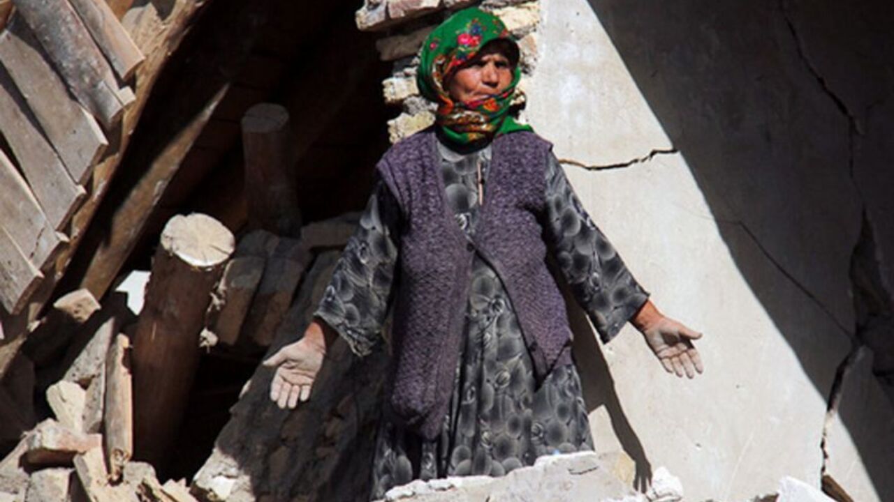 An earthquake victim stands near a damaged house in the earthquake-stricken town of Azerbaijan An earthquake victim stands near a damaged house in the earthquake-stricken town of Azerbaijan in Iran, August 13, 2012. Rescue workers in Iran on Tuesday recovered more bodies three days after two powerful earthquakes struck the northwest of the country, killing more than 300 people, but officials played down reports that casualty numbers may still sharply rise. Picture taken August 13, 2012. REUTERS/Farshid Tighehsaz/ISNA (IRAN - Tags: DISASTER) FOR EDITORIAL USE ONLY. NOT FOR SALE FOR MARKETING OR ADVERT