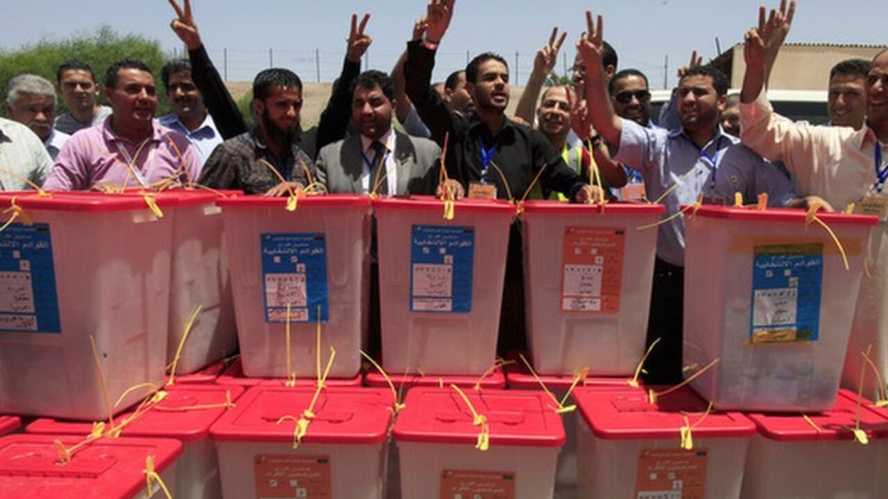 High Election Commission workers chant the national anthem behind ballot boxes which just arrived from the region of Kufra, in Tripoli High Election Commission workers chant the national anthem behind ballot boxes which just arrived from the region of Kufra, five days after Saturday's landmark national elections, at the High Election Commission Center in Tripoli July 12, 2012. Voting in Kufra was held up by security problems in the area, with anti-poll protesters attacking election facilities. Libyans, relieved that their first free national election in 60 years had survived violence and protests, celebrated the chance to draw a line under
