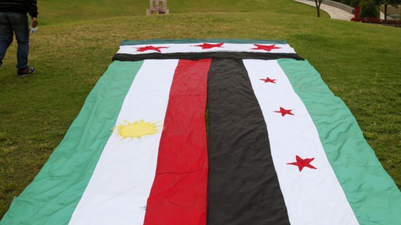 A Syrian Kurd walks past giant Kurdish and Syrian opposition flags ahead in front of the UN headquarters in Beirut, in solidarity with anti-government protesters in Syria A Syrian Kurd walks past giant Kurdish (L) and Syrian opposition flags ahead of a sit-in in front of the United Nations headquarters in Beirut, in solidarity with anti-government protesters in Syria, April 29, 2012. REUTERS/Cynthia Karam (LEBANON - Tags: POLITICS CIVIL UNREST)