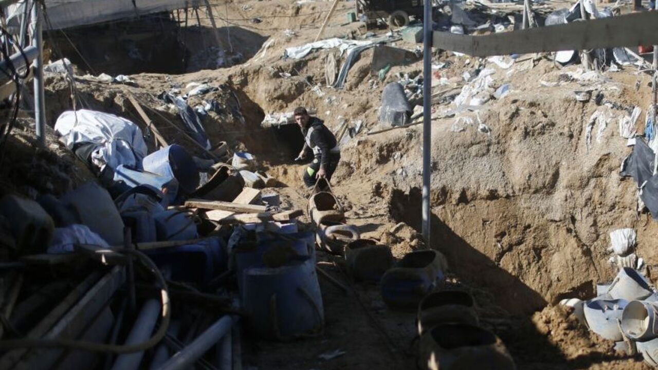 A Palestinian works at the entrance of a smuggling tunnel dug beneath the Egyptian-Gaza border in the southern Gaza Strip A Palestinian works at the entrance of a smuggling tunnel dug beneath the Egyptian-Gaza border in Rafah, in the southern Gaza Strip November 26, 2012. Knee-deep in craters carved out by Israeli air strikes, Palestinians wielded shovels and planks to reopen tunnels used to smuggle in goods from Egypt to Gaza, as international aid agencies raced to replenish Gaza's supplies. REUTERS/Mohammed Salem (GAZA - Tags: CIVIL UNREST CONFLICT)