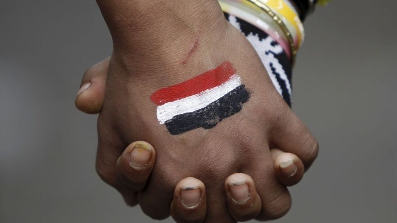 Anti-Mursi protesters, who want a peaceful demonstration, join hands as they try to stop clashes and rock-throwing at riot police along a road which leads to the U.S. embassy, near Tahrir Square in Cairo Anti-Mursi protesters, who want a peaceful demonstration, join hands as they try to stop clashes and rock-throwing at riot police along a road which leads to the U.S. embassy, near Tahrir Square in Cairo November 29, 2012. The body writing Egypt's new constitution began a session to vote on a final draft on Thursday, a move President Mohamed Mursi's allies in the Muslim Brotherhood hope will help end a crisis prompted by a decree expanding his powers. Seen on the hand is an image of the Egyptian flag. REUTE