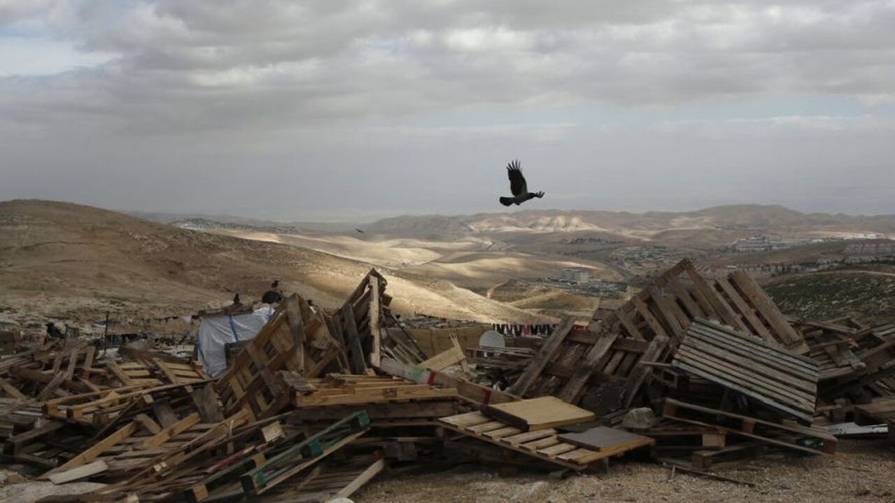 A bird flies over pieces of wood in an area near Jerusalem known as E1 A bird flies over pieces of wood in an area near Jerusalem known as E1, where there are plans for construction of some 3,000 settler homes December 6, 2012. Germany's Angela Merkel and Israel's Benjamin Netanyahu agreed to disagree on the question of Israeli plans to build more Jewish settlements, the chancellor said on Thursday. REUTERS/Baz Ratner (WEST BANK - Tags: POLITICS ANIMALS)