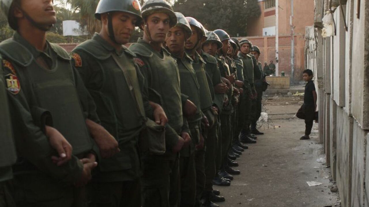A boy leans against a newly built barrier, in front of soldiers standing guard outside the Egyptian presidential palace in Cairo A boy leans against a newly built barrier, in front of soldiers standing guard outside the Egyptian presidential palace in Cairo December 9, 2012. A concession offered by President Mohamed Mursi failed to placate opponents who accused him on Sunday of plunging Egypt deeper into crisis by refusing to postpone a vote on a constitution shaped by Islamists. REUTERS/Asmaa Waguih (EGYPT - Tags: POLITICS CIVIL UNREST MILITARY TPX IMAGES OF THE DAY)