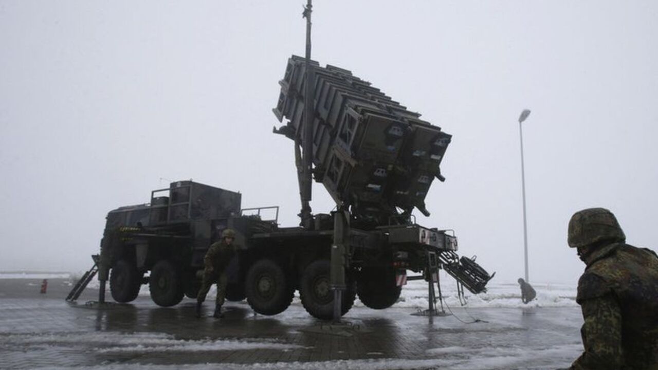 Soldiers of the Bundeswehr stand next to a PAC-2 launcher of a "Patriot" missile battery during a media rehearsal in Warbelow Soldiers of the German armed forces Bundeswehr stand next to a PAC-2 launcher of a "Patriot" missile battery during a media rehearsal in the north German village of Warbelow December 18, 2012. Germany's lower house of parliament, the Bundestag, last week approved the sending of two Patriot batteries and 400 soldiers to Turkey as part of a NATO plan to protect the country from any spread of the Syrian conflict. REUTERS/Tobias Schwarz (GERMANY - Tags: POLITICS MILITARY CIVIL UNREST)