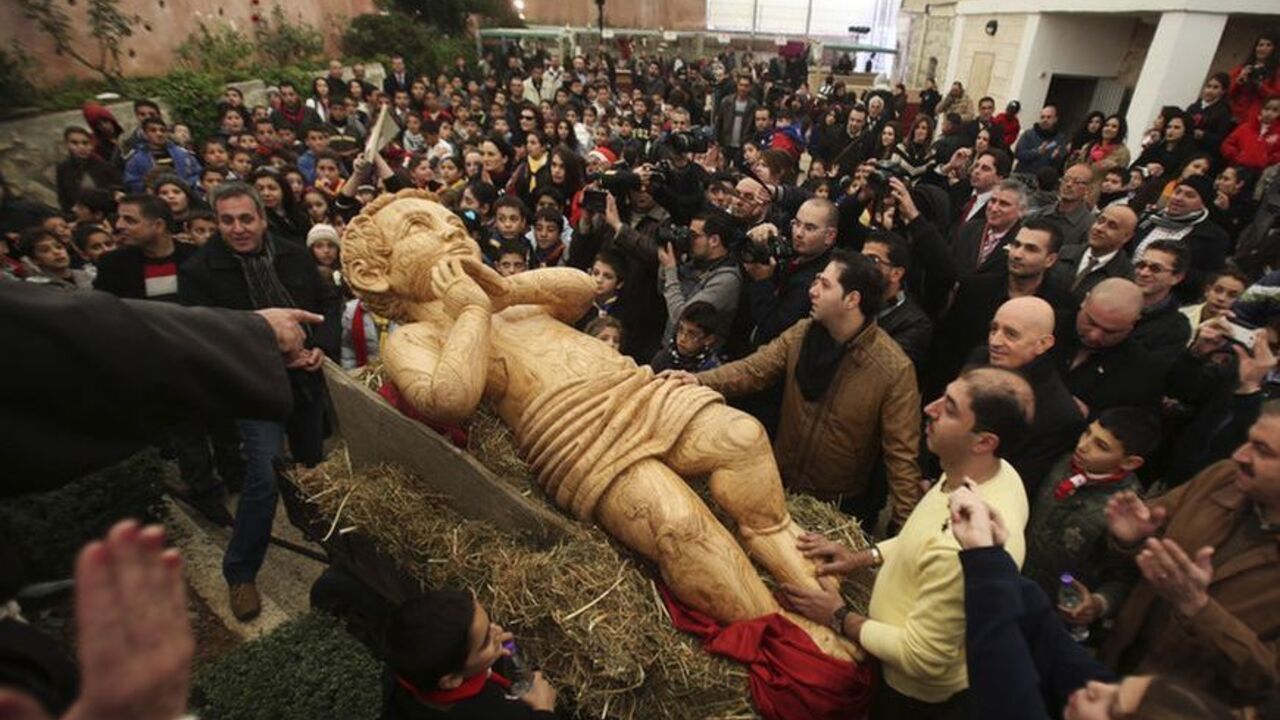 Palestinians surround a cart carrying a wooden statue of baby Jesus before a march in Bethlehem ahead of Christmas Palestinians surround a cart carrying a wooden statue of baby Jesus before a march in the West Bank town of Bethlehem December 20, 2012, ahead of Christmas. REUTERS/Mohamad Torokman (WEST BANK - Tags: RELIGION TPX IMAGES OF THE DAY)