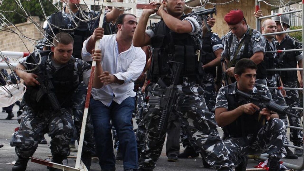 Lebanese security forces reinforce the barriers during clashes with protesters who were trying to storm the Lebanese government in Beirut Lebanese security forces reinforce the barriers during clashes with protesters who were trying to storm the Lebanese government in Beirut October 21, 2012. Angry mourners marched on Lebanese Prime Minister Najib Mikati's offices in central Beirut on Sunday, breaking through an outer security barrier and scuffling with police who fired tear gas in response. "Mikati leave, get out," chanted hundreds of protesters following the funeral of a slain intelligence chief. REUTERS/Ahmed Jadallah (LEBANON- Tags: POLIT