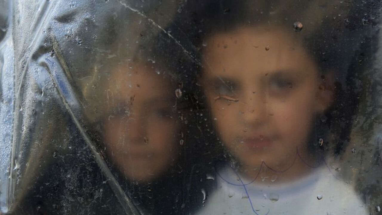 A Syrian refugee girl looks from behind a plastic sheet inside the makeshift tent where she temporarily lives with her family in Bar Elias village in the Bekaa valley A Syrian refugee girl looks from behind a plastic sheet inside the makeshift tent where she temporarily lives with her family in Bar Elias village in the Bekaa valley December 13, 2012.REUTERS/ Jamal Saidi (LEBANON - Tags: POLITICS CIVIL UNREST)