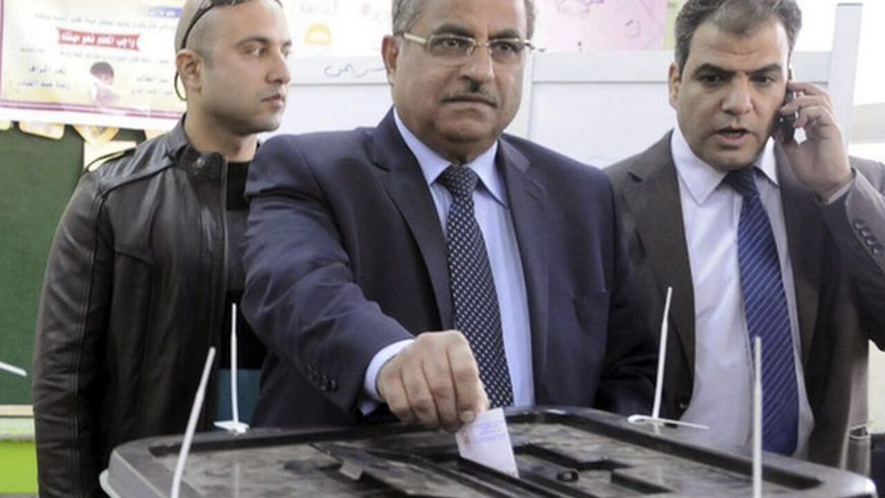 Shura Council Chairman Fahmy waits in line to vote in a referendum on Egypt's new constitution, in Zagazig Shura Council Chairman Ahmed Fahmy (C) casts his vote in a referendum on Egypt's new constitution, at a polling station in Zagazig, Sharqiya Governorate, about 62.5 km (38.8 miles) northeast of Cairo December 15, 2012. Egyptians queued in long lines on Saturday to vote on a constitution promoted by its Islamist backers as the way out of a political crisis and rejected by opponents as a recipe for further divisions in the Arab world's biggest nation. REUTERS/Stringer (EGYPT - Tags: POLITICS ELECTIONS)