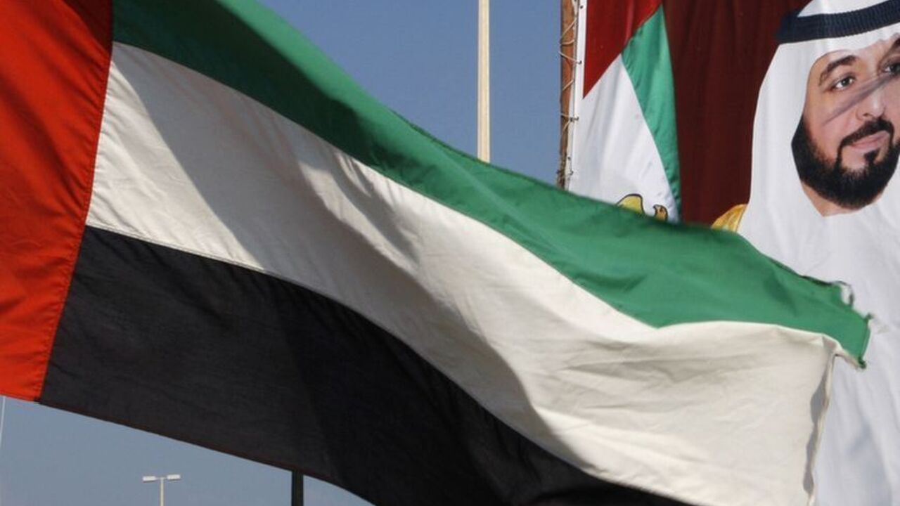 A United Arab Emirates flag waves in front of a big poster of President Sheikh Khalifa bin Zayed al-Nahayan in Abu Dhabi A United Arab Emirates flag waves in front of a big poster of President Sheikh Khalifa bin Zayed al-Nahayan in Abu Dhabi December 15,2009. Abu Dhabi threw its flashy but debt-laden neighbour Dubai a $10 billion lifeline to head off a bond default, cheering Gulf and global markets on Monday but raising questions about the undisclosed terms.REUTERS/Ahmed Jadallah (UNITED ARAB EMIRATES - Tags: TRAVEL SOCIETY BUSINESS CITYSCAPE)