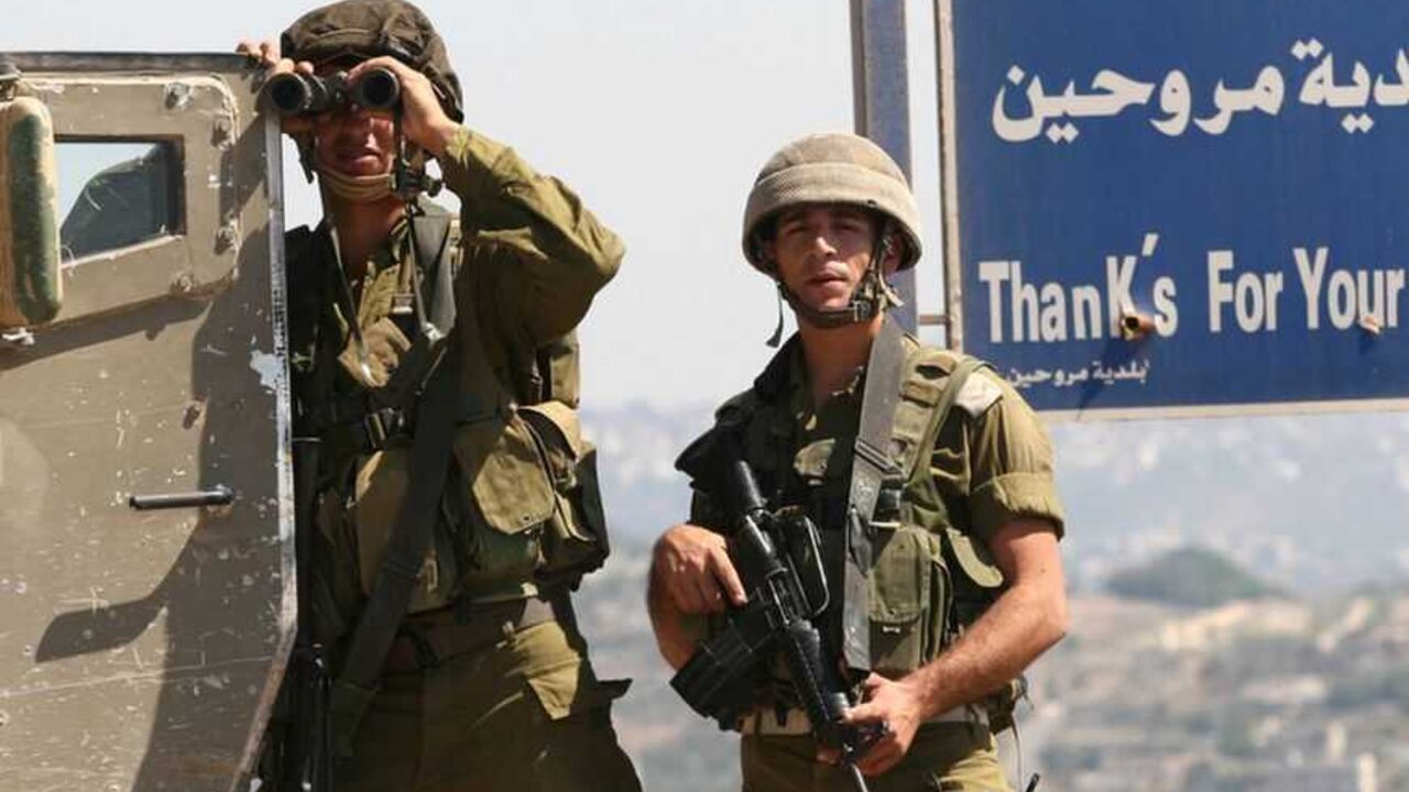 An Israeli soldier uses a pair of binoculars by the entrance of Marwahine village in south Lebanon September 27, 2006. REUTERS/Ali Hashisho (LEBANON)