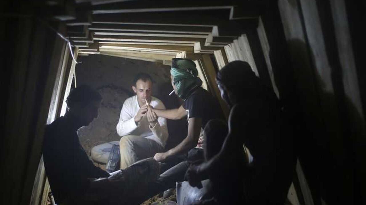 Palestinians smoke cigarettes as they work inside a smuggling tunnel dug beneath the Egyptian-Gaza border in the southern Gaza Strip Palestinians smoke cigarettes as they work inside a smuggling tunnel dug beneath the Egyptian-Gaza border in Rafah, in the southern Gaza Strip November 26, 2012. Knee-deep in craters carved out by Israeli air strikes, Palestinians wielded shovels and planks to reopen tunnels used to smuggle in goods from Egypt to Gaza, as international aid agencies raced to replenish Gaza's supplies. REUTERS/Mohammed Salem (GAZA - Tags: CONFLICT) - RTR3AWAH