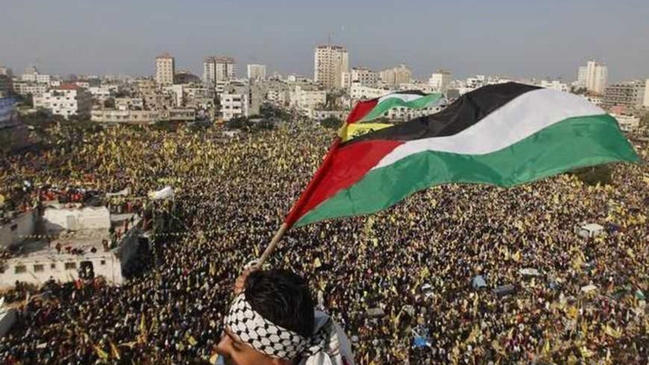 A boy waves a Palestinian flag during a rally marking the 48th anniversary of the founding of the Fatah movement in Gaza City A boy waves a Palestinian flag during a rally marking the 48th anniversary of the founding of the Fatah movement, in Gaza City January 4, 2013. Hundreds of thousands of Palestinians joined a rare rally staged by President Mahmoud Abbas's Fatah group in Gaza on Friday, as tensions ease with rival Hamas Islamists ruling the enclave since 2007. REUTERS/Mohammed Salem (GAZA - Tags: POLITICS ANNIVERSARY) - RTR3C3GR
