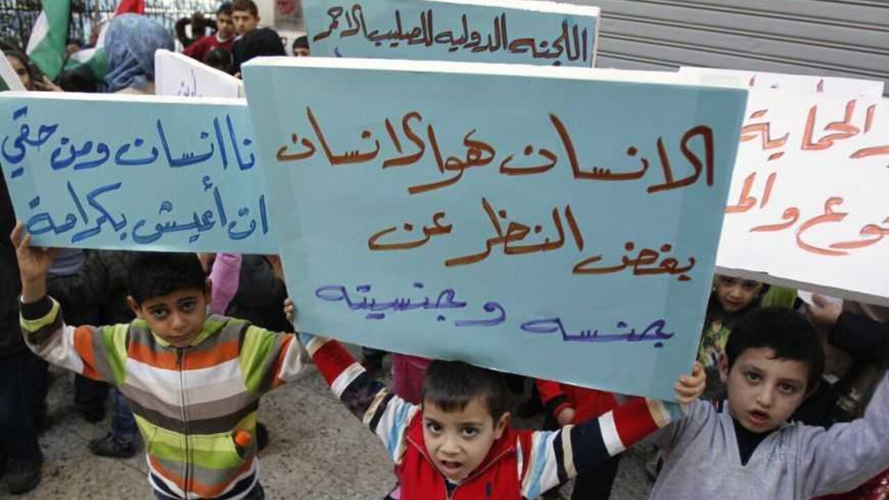 Palestinian children who were living in Yarmouk Palestinian refugee camp before fleeing Syria, hold banners during protest in Beirut Palestinian children who were living in Yarmouk Palestinian refugee camp before fleeing Syria, hold banners during a protest in front of the International Committee of the Red Cross (ICRC) in Beirut January 17, 2013. Banners read, "Man is man, regardless of gender and nationality" (C), "I am a human and I have the right to live with dignity" (L) and "We want protection from hunger and diseases". REUTERS/Sharif Karim (LEBANON - Tags: SOCIETY IMMIGRATION POLITICS CONFLICT)