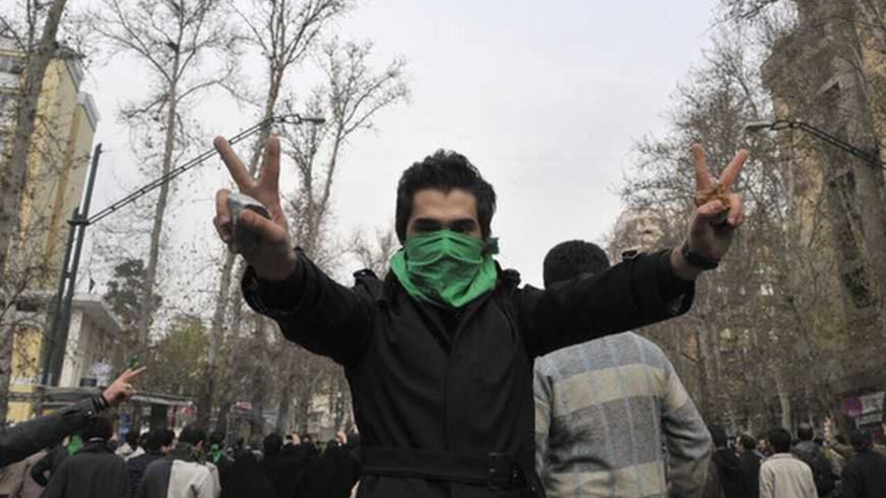 An Iranian protestor flashes the victory sign as he holds stones in his hands during clashes in central Tehran EDITORS' NOTE: Reuters and other foreign media are subject to Iranian restrictions on their ability to film or take pictures in Tehran.
An Iranian protestor with his face covered with a green mask flashes the victory sign as he holds stones in his hands during clashes in central Tehran December 27, 2009. A senior Iranian police official denied a report on an opposition website that four pro-reform protesters were killed during clashes in Tehran on Sunday, the Students News Agency ISNA reported. REUTERS/S