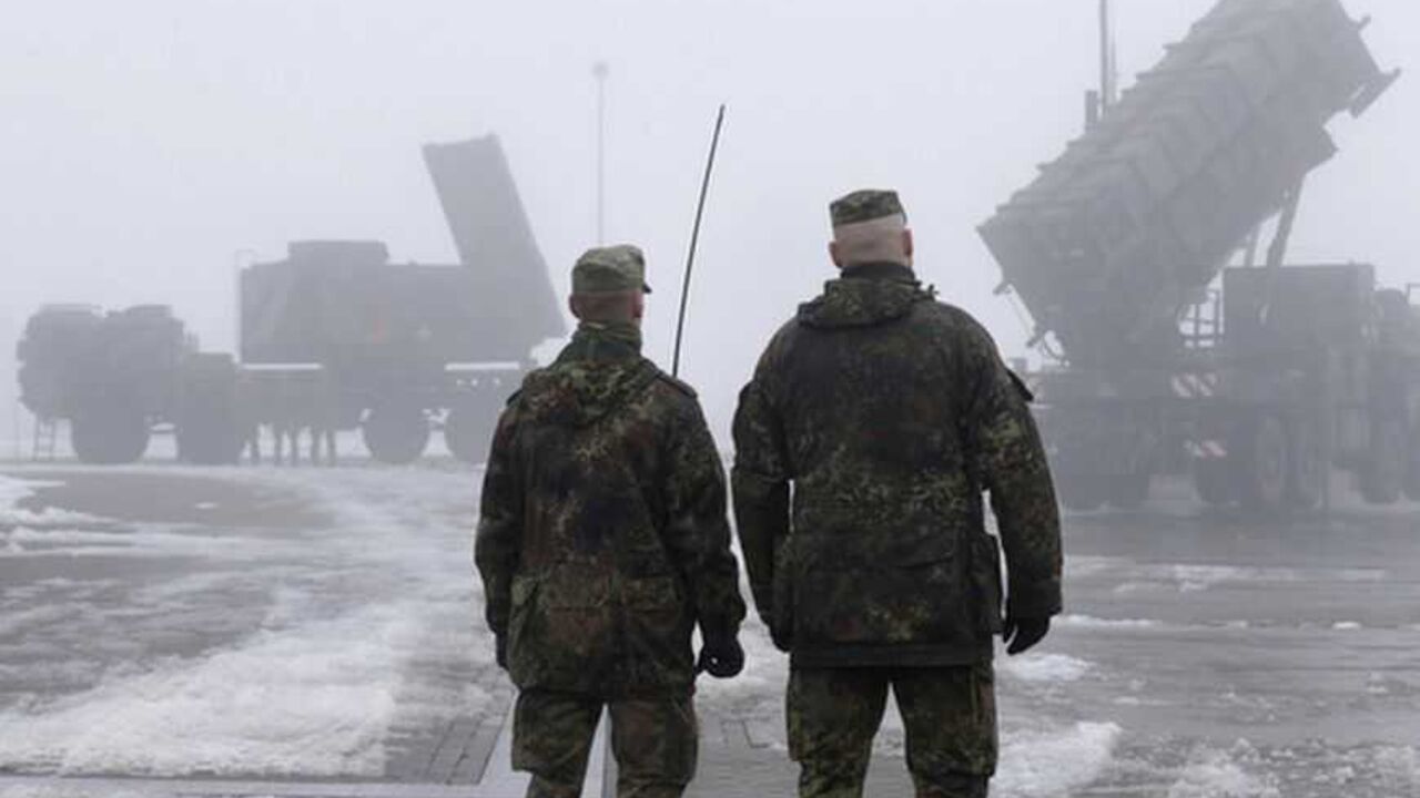 Soldiers of German Bundeswehr stand next to "Patriot" missile battery during press rehearsal in Warbelow Soldiers of the German armed forces Bundeswehr stand next to a radar-unit (L) and a PAC-2 launcher of a "Patriot" missile battery during a press rehearsal in the north German village of Warbelow December 18, 2012. Germany's lower house of parliament, the Bundestag, last week approved the sending of two Patriot batteries and 400 soldiers to Turkey as part of a NATO plan to protect the country from any spread of the Syrian conflict. REUTERS/Tobias Schwarz (GERMANY - Tags: POLITICS MILITARY CONFLICT)