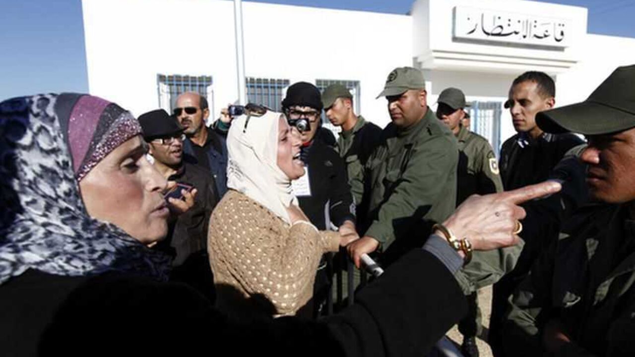 Tunisian protester gestures towards police officer during demonstration outside Mornaguia jail calling for the liberation of Fehri, TV producer and director of Ettounsiya Television, in Tunis A Tunisian protester gestures towards a police officer during a demonstration outside Mornaguia jail calling for the liberation of Sami Fehri, TV producer and director of Ettounsiya Television, in Tunis December 24, 2012. REUTERS/Anis Mili (TUNISIA - Tags: POLITICS CIVIL UNREST SOCIETY)