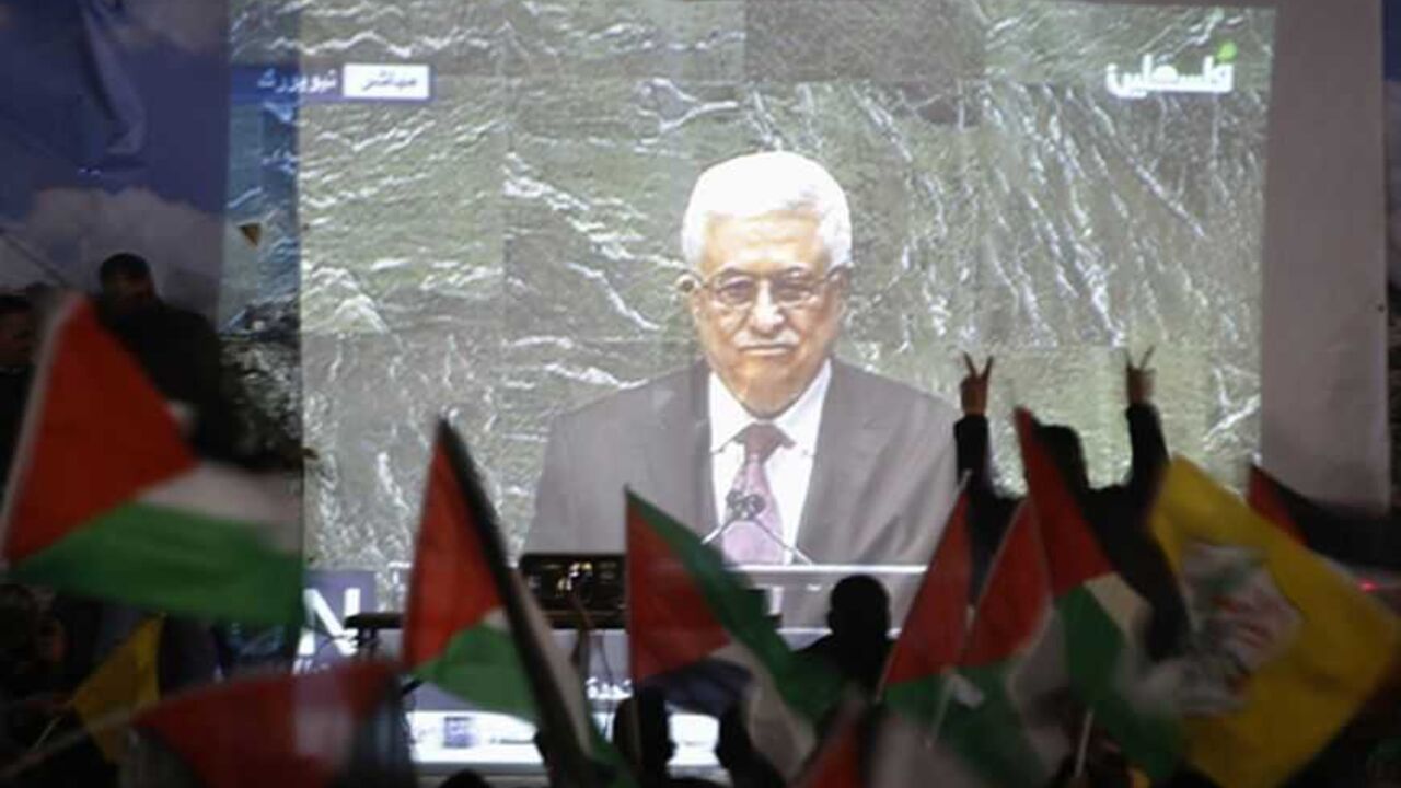 PALESTINIANS-STATEHOOD/ABBAS Palestinians take part in a rally while the speech of Palestinian President Mahmoud Abbas is being projected in the West Bank city of Ramallah November 29, 2012. The 193-nation U.N. General Assembly overwhelmingly approved a resolution on Thursday to upgrade the Palestinian Authority's observer status at the United Nations from "entity" to "non-member state," implicitly recognizing a Palestinian state. REUTERS/Mohamad Torokman (WEST BANK - Tags: POLITICS)