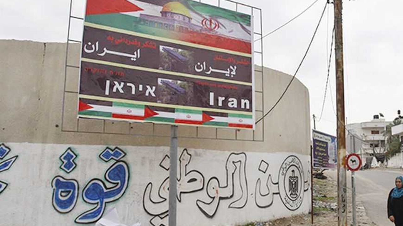 PALESTINIANS-ISRAEL/ A Palestinian woman walks next to a banner that reads "Thanks and gratitude to Iran" in Gaza City November 27, 2012. Senior Hamas leader Mahmoud al-Zahar showed how fragile the ceasefire between Israel and Palestinians remained, with defiant remarks to reporters recently of how the Islamists would go on smuggling in weapons "by all possible means", including via Israel's arch-foe Iran. REUTERS/Ahmed Zakot (GAZA - Tags: CIVIL UNREST CONFLICT)