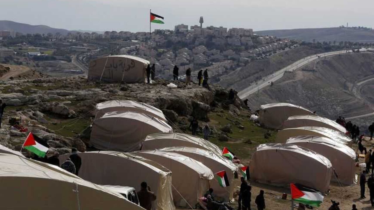Palestinians, together with Israeli and foreign activists, stand near newly-erected tents in an area known as E1, near Jerusalem Palestinians, together with Israeli and foreign activists, stand near newly-erected tents in an area known as E1, near Jerusalem January 12, 2013. Palestinians from villages in the occupied West Bank near Jerusalem pitched tents on Friday on the land Israel has earmarked for a new urban settlement, looking to preserve the area for an independent Palestinian state. REUTER/Baz Ratner (WEST BANK - Tags: POLITICS CIVIL UNREST BUSINESS CONSTRUCTION) - RTR3CD0D