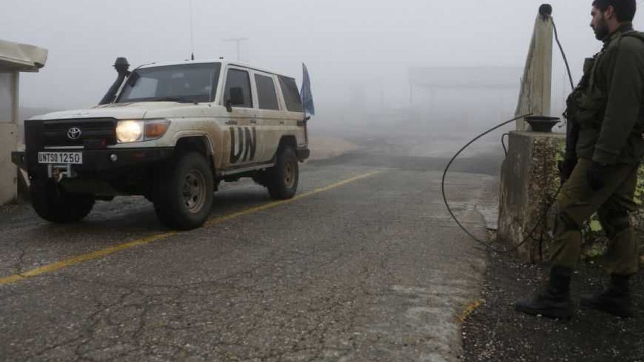 An Israeli soldier looks on as a U.N. jeep drives past the Quneitra border crossing between Israel and Syria, in the Golan Heights An Israeli soldier looks on as a United Nations jeep drives past the Quneitra border crossing between Israel and Syria, in the Golan Heights, on the Israeli side of the 1973 ceasefire line with Syria January 31, 2013. Israeli forces attacked a convoy on the Syrian-Lebanese border overnight, a Western diplomat and regional security sources said on Wednesday, as concern has grown in the Jewish state over the fate of Syrian chemical and advanced conventional weapons. REUTERS/Baz Ratner (POLITICS CIVIL UNREST)