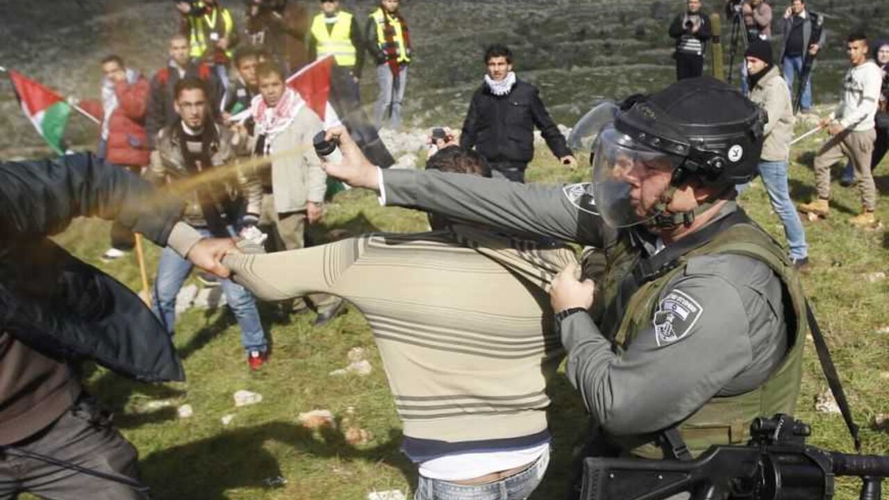 An Israeli border police officer uses pepper spray to disperse Palestinian activists after the group set up tents and makeshift structures in protest against a nearby Jewish settlement in the West Bank village of Burin, south of Nablus An Israeli border police officer uses pepper spray to disperse Palestinian activists after the group set up tents and makeshift structures in protest against a nearby Jewish settlement in the West Bank village of Burin, south of Nablus February 2, 2013. Palestinians who set up a makeshift encampment in the occupied West Bank on Saturday clashed with Israeli soldiers and settlers and some light injuries were sustained.
REUTERS/Mohamad Torokman (WEST BANK - Tags: POLITICS RELIGION CIVIL UNREST TPX IMAGES OF T