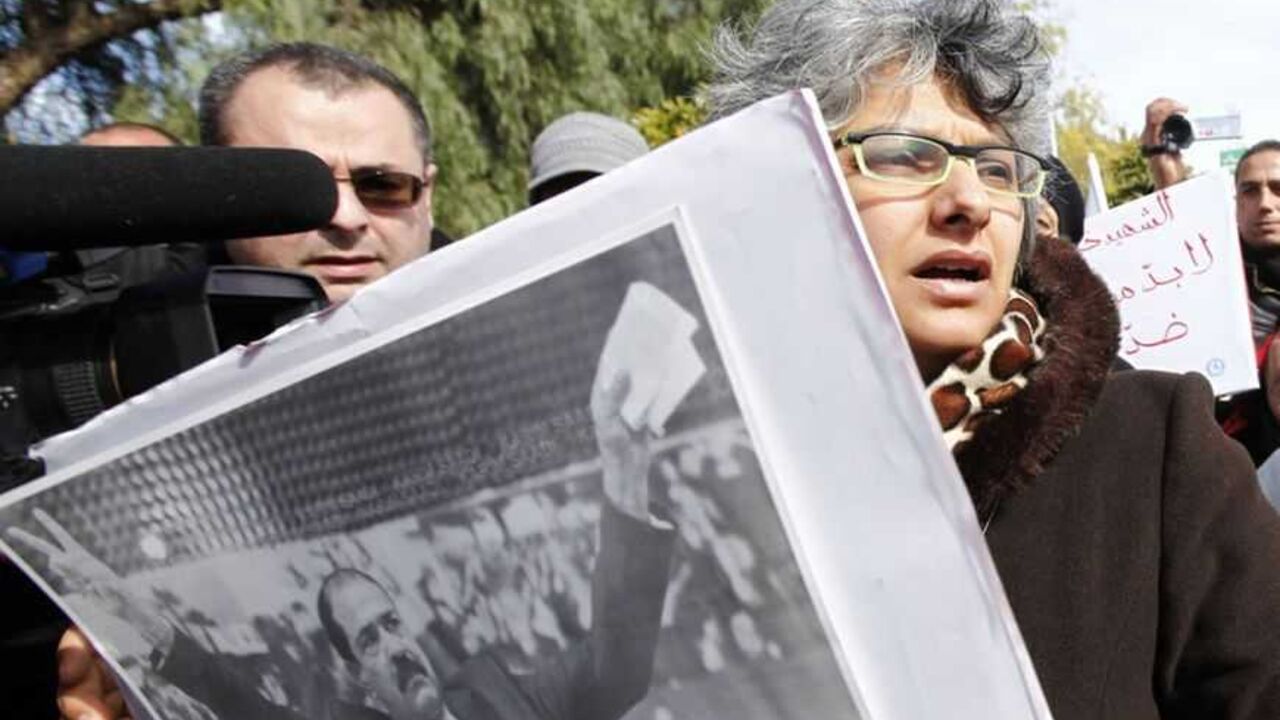 Basma Beliad carries a poster of her husband during a demonstration calling for Jebali and his cabinet to step down in Tunis Basma Beliad, the widow of assassinated leftist politician Chokri Belaid, carries a poster of her husband as she's surrounded by journalists, during a demonstration calling for Prime Minister Hamadi Jebali and his cabinet to step down, next to the National Constituent Assembly in Tunis, February 11, 2013. A party led by interim President Moncef Marzouki said on Monday it had "frozen" its withdrawal from Tunisia's coalition government while talks continue on a political crisis sharpened by the killing of an