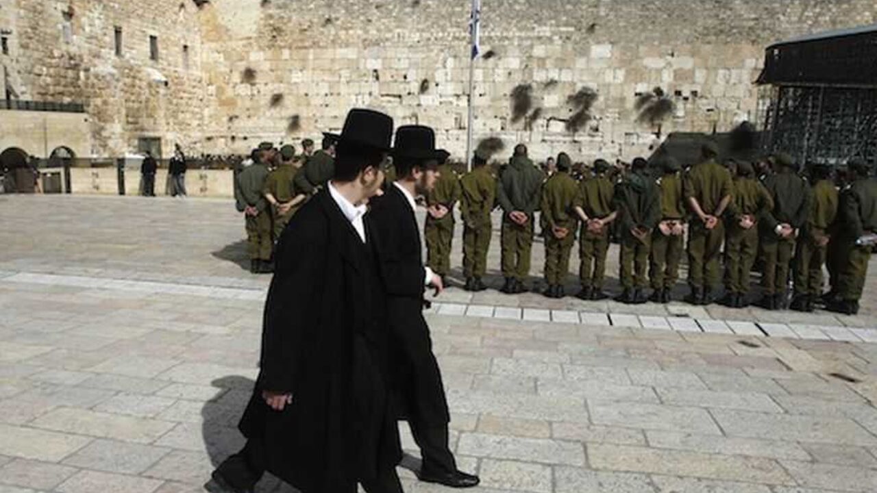 To match Insight ISRAEL/RELIGION-IDF Ultra-Orthodox Jewish men walk behind Israeli soldiers at the Western Wall, Judaism's holiest prayer site, in Jerusalem's Old City February 22, 2012. The Israeli Defence Force (IDF) has always been a 'Jewish' army. Its rations are kosher, its chaplains are rabbis, and it operates - with the exception of wartime - around the festival calendar. It has never drafted soldiers from Israel's 20-percent Arab minority. But its Jewish identity has always been more cultural than religious. IDF personnel data suggests