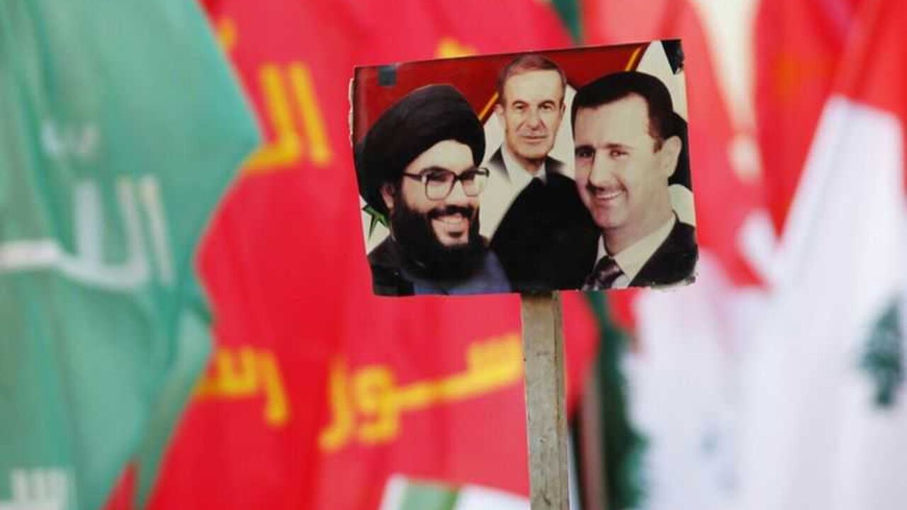 Supporters of Nasrallah wave flags and a picture depicting Nasrallah, Hafez al-Assad, Bashar al-Assad at a protest against a film made in the U.S. that mocks the Prophet Mohammad, in Bint Jbeil Supporters of Lebanon's Hezbollah leader Sayyed Hassan Nasrallah wave flags and a picture depicting (L-R) Lebanon's Hezbollah leader Sayyed Hassan Nasrallah, Syria's late President Hafez al-Assad, father of current President Bashar al-Assad at a protest against a film made in the U.S. that mocks the Prophet Mohammad, in the southern Lebanese town of Bint Jbeil September 22, 2012. REUTERS/Ali Hashisho (LEBANON - Tags: POLITICS CIVIL UNREST RELIGION) - RTR38A9D