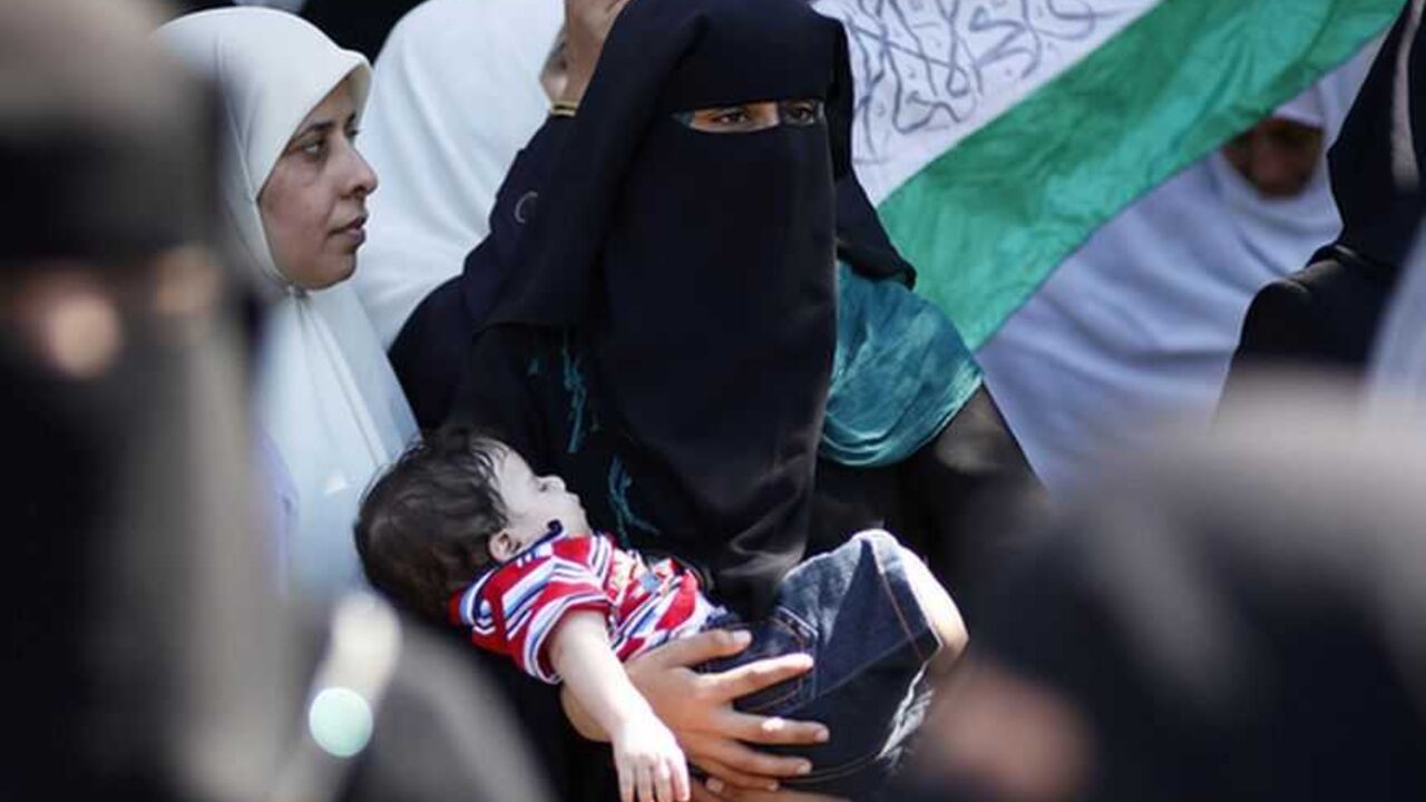 A Palestinian woman holds her son during a protest in Gaza City A Palestinian woman holds her son during a protest in Gaza City calling for the release of Palestinian prisoners from Israeli jails September 24, 2012. REUTERS/Mohammed Salem (GAZA - Tags: POLITICS CIVIL UNREST) - RTR38CL0
