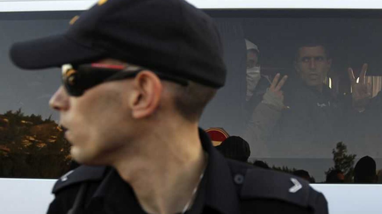 An Israeli police officer stands in front of protesters after they were detained in an area known as "E1" near Jerusalem An Israeli police officer stands in front of Palestinian and foreign protesters gesturing from inside a vehicle after they were detained in an area known as "E1", which connects the two parts of the Israeli-occupied West Bank outside Arab suburbs of East Jerusalem January 15, 2013. Israeli police, using stun grenades, blocked about 50 Palestinian activists who tried on Tuesday to reoccupy tents they pitched last week on a patch of West Bank land which Israel wants for Jewish settlements. REUTERS/Ammar Awad