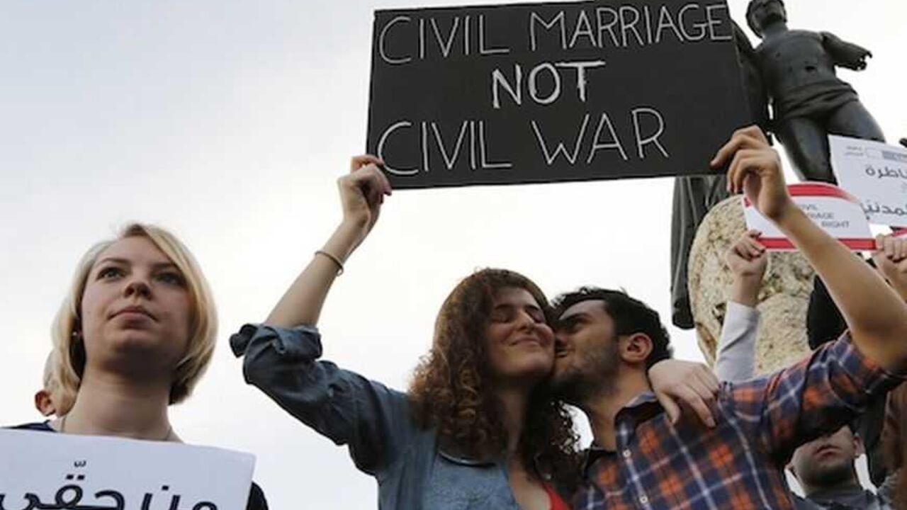 A man kisses a woman as they hold up a placard during a protest demanding to legalize civil marriage in Lebanon, at Martyrs' square in downtown Beirut A man kisses a woman as they hold up a placard during a protest demanding to legalize civil marriage in Lebanon, at Martyrs' square in downtown Beirut February 4, 2013. Lebanese laws do not recognise civil marriages conducted in Lebanon. REUTERS/Jamal Saidi (LEBANON - Tags: CIVIL UNREST) - RTR3DCHX