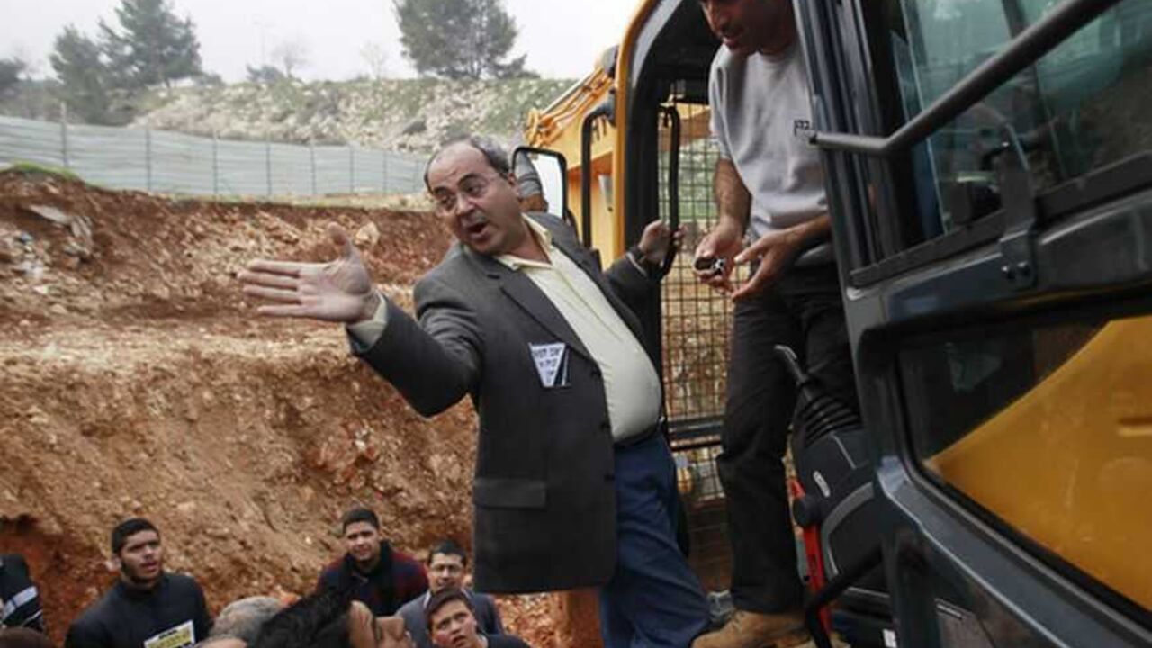 Israeli Arab Parliament member Ahmed Tibi stands on a bulldozer during a demonstration against Israel's construction of a road in Beit Safafa in Jerusalem Israeli Arab Parliament member Ahmed Tibi (C) gestures as he stands on a bulldozer during a demonstration against Israel's construction of a road in the Arab neighbourhood of Beit Safafa in Jerusalem February 10, 2013. Some 50 Palestinians protested against the construction of the road, which they claim is an expropriation of their land. REUTERS/Ammar Awad (JERUSALEM - Tags: POLITICS CIVIL UNREST BUSINESS CONSTRUCTION) - RTR3DL5H