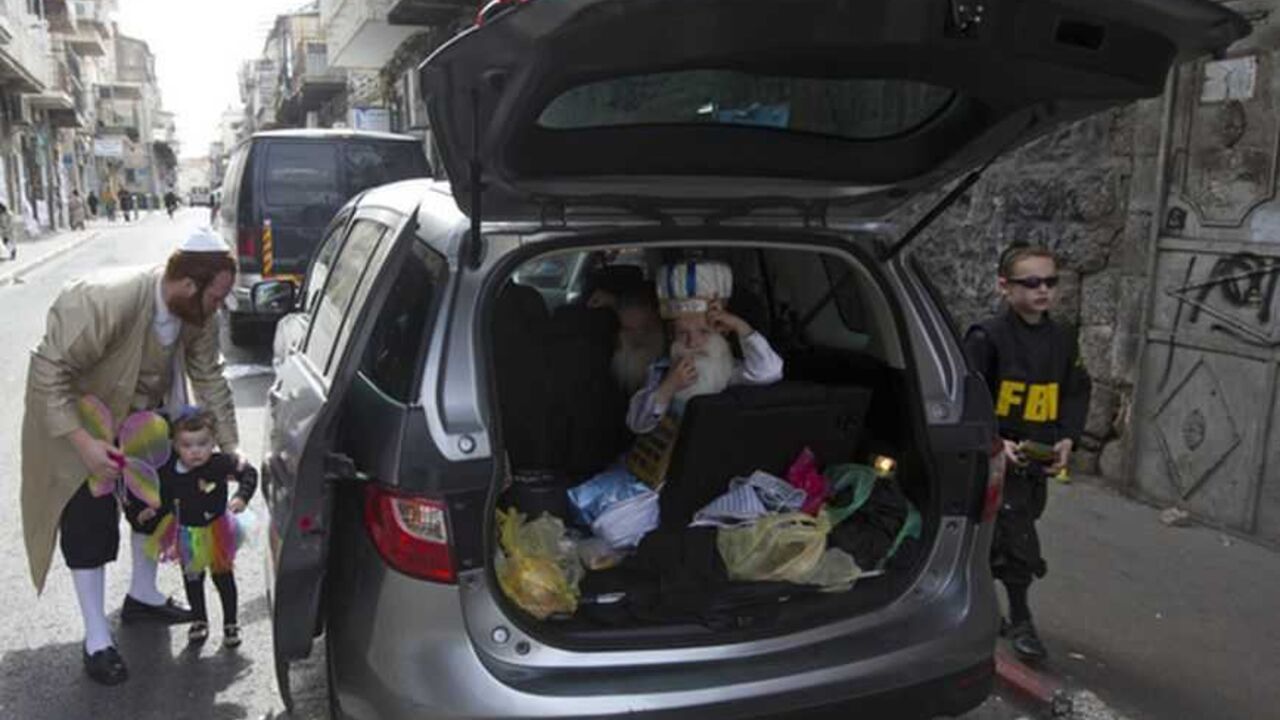 Children wearing costumes for the Jewish holiday of Purim wait to get out of a car in Jerusalem's Mea Shearim neighbourhood Children wearing costumes for the Jewish holiday of Purim wait to get out of a car in Jerusalem's Mea Shearim neighbourhood February 25, 2013. Purim is a celebration of the Jews' salvation from genocide in ancient Persia, as recounted in the Book of Esther. REUTERS/Ronen Zvulun (JERUSALEM - Tags: RELIGION) - RTR3E9X6